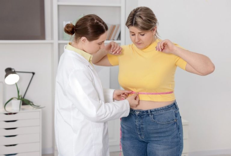 Houston weight loss doctor measuring patient’s waist—clinical exam for personalized health and fitness guidance