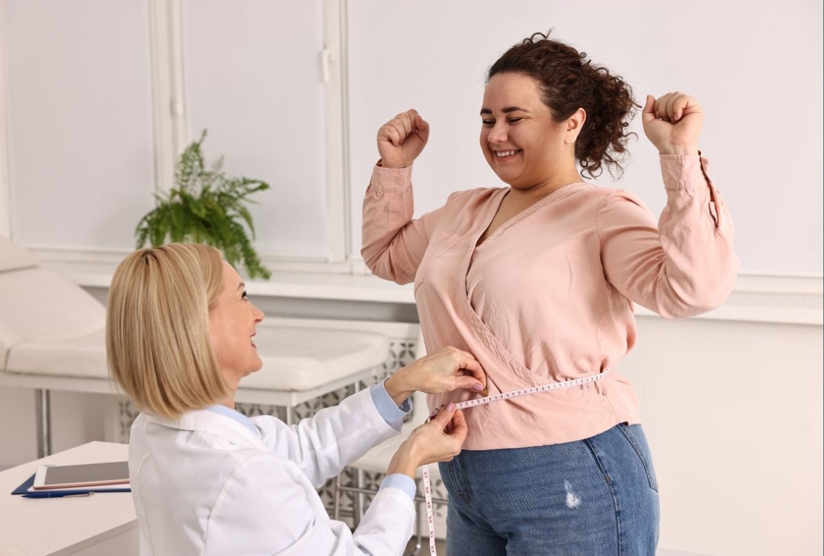Healthcare expert measuring patient’s waist during Weight Loss Injections Houston consultation for fat reduction.