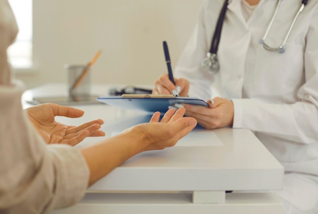 Houston weight loss doctor consulting patient—clipboard notes and stethoscope show personalized health planning.