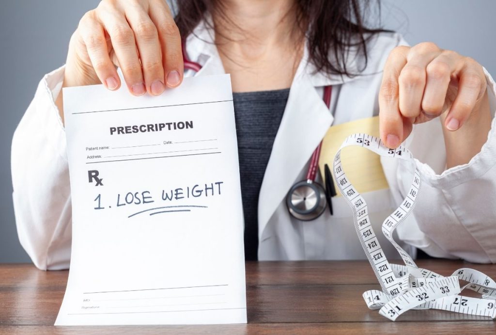 Prescription for weight loss shown by Houston doctor—medical tape and Rx pad highlight clinical weight guidance.