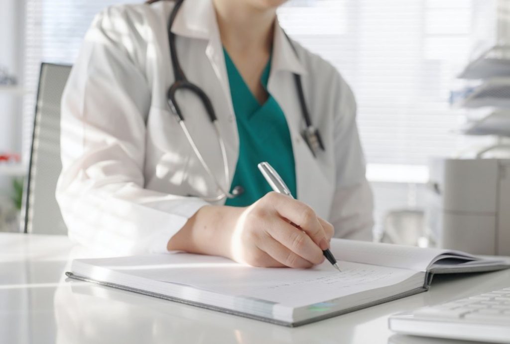Healthcare professional documenting patient chart at weight loss clinic Houston, stethoscope visible in clean, well-lit office