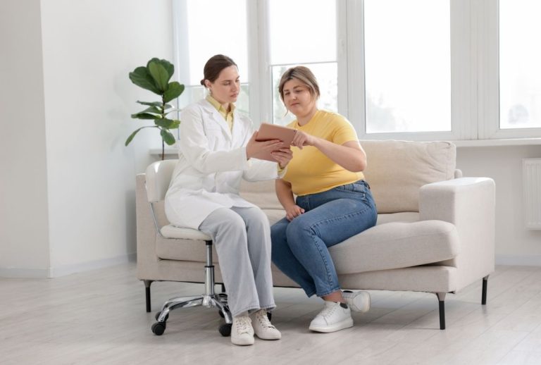 Doctor and patient reviewing tablet together in a bright medical office, highlighting collaborative weight loss planning.