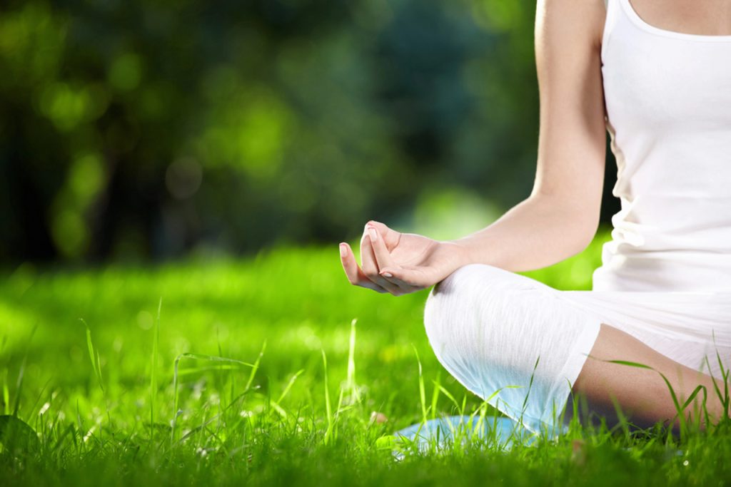 Calm woman practicing mindfulness and meditation in a Houston park to support a Semaglutide Houston wellness lifestyle.