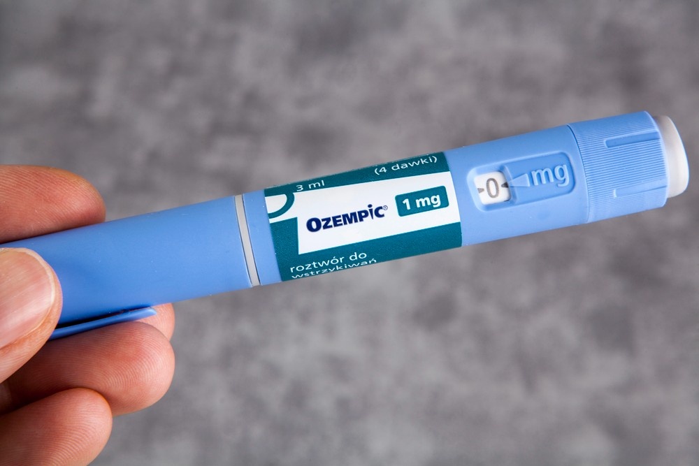 A person holding an Ozempic 1mg injection pen, often used as part of a supervised medical weight loss plan in Houston.