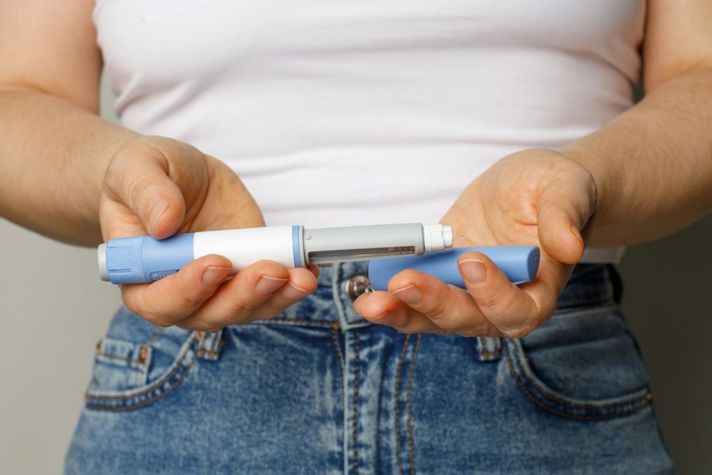 Cupped hands holding a blue medication pen, representing accessible zepbound coverage houston weight loss plans.
